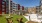 a courtyard with chairs and tables and buildings in the background